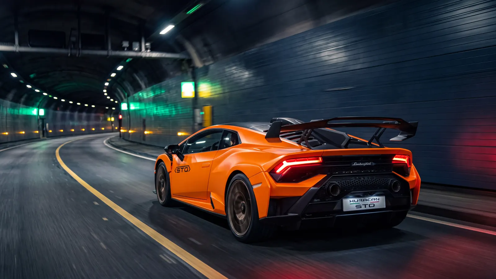 Lamborghini Huracán STO orange de La Menace lancée dans un tunnel de nuit
